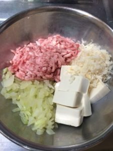 ハンバーグ下準備でひき肉と玉ねぎと豆腐とパン粉をボウルに入れた様子